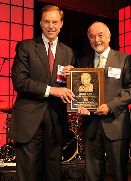 Stu Levenik (President AEM und Group President Caterpillar), links, und Dr. Theo Freye (Sprecher der CLAAS Geschäftsführung) präsentieren eine Plakette mit dem Portrait von Helmut Claas. Sie wurde anlässlich seiner Aufnahme in die Hall of Fame angefertigt. -